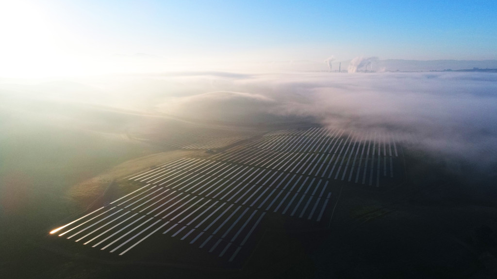 Large-scale solar installation amidst a misty dawn.